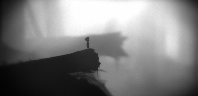 Limbo protagonist stands on the edge of a fallen tree, overlooking a fog-covered valley